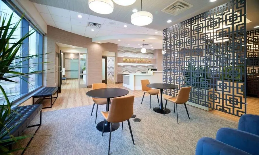 Cafe tables and leather chairs by the coffee bar in the Woodbury Dental Care lobby.