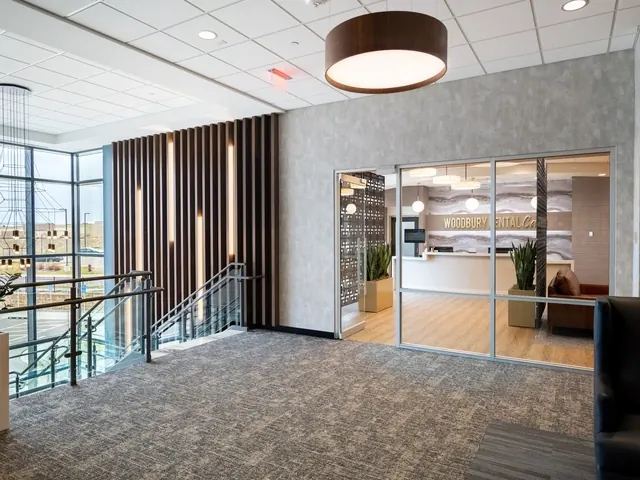 The second-floor landing at 215 Radio Drive and the glass doors into Woodbury Dental Care.