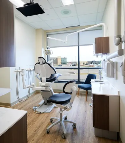 A treatment room with a window over Woodbury and a ceiling-mounted TV.