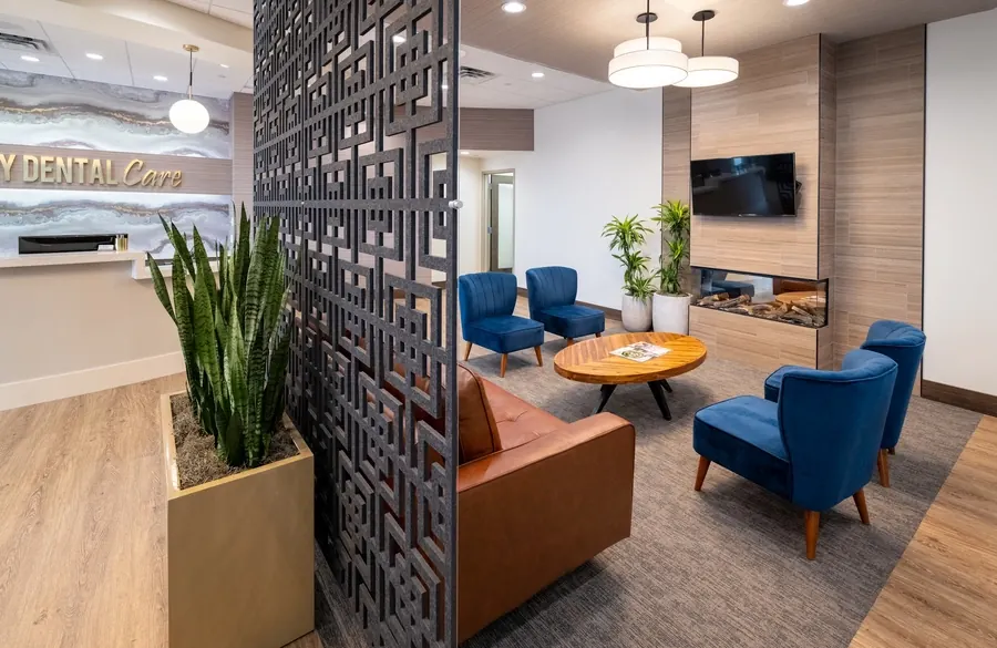 The lobby lounge: blue armchairs and a round table in front of the fireplace and a TV.